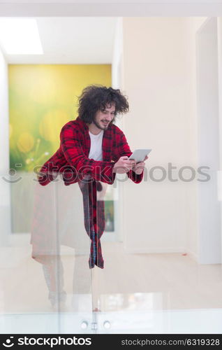 young freelancer in bathrobe working from home using tablet computer