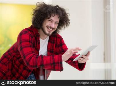 young freelancer in bathrobe working from home using tablet computer