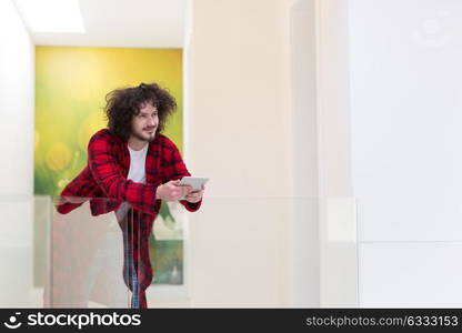 young freelancer in bathrobe working from home using tablet computer