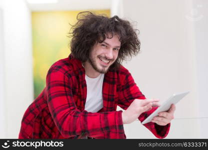 young freelancer in bathrobe working from home using tablet computer