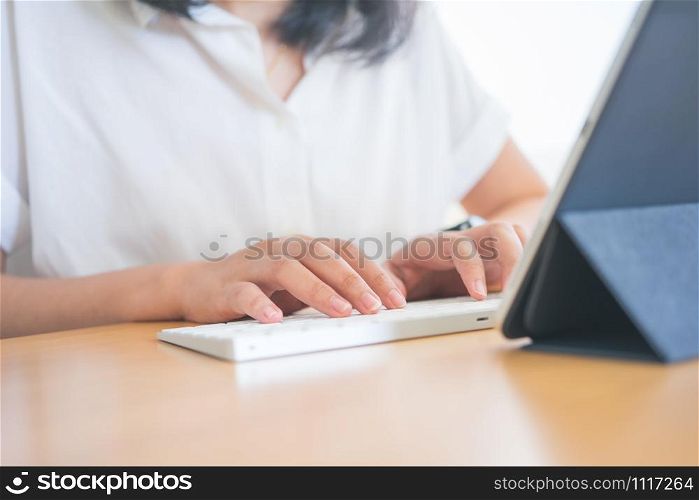 Young Freelancer or Businessman working at home office and typing on keyboard smartphone tablet. Working Online Or Studying And Learning While Using smartphone tablet. Freelance Work, Business concept