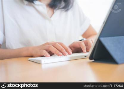 Young Freelancer or Businessman working at home office and typing on keyboard smartphone tablet. Working Online Or Studying And Learning While Using smartphone tablet. Freelance Work, Business concept