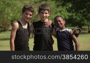 Young friends and recreation, three happy children with baseball smiling at camera
