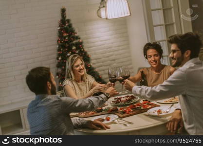 Young friends celebrating Christmas or New Year eve at home