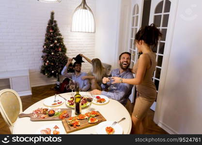 Young friends celebrating Christmas or New Year eve at home