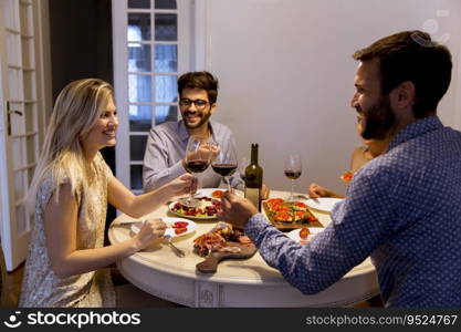 Young friends celebrating Christmas or New Year eve at home