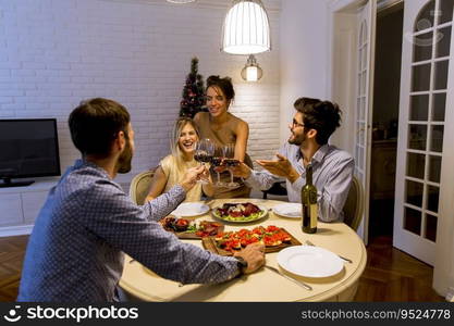 Young friends celebrating Christmas or New Year eve at home