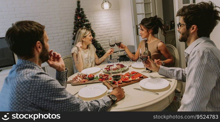 Young friends celebrating Christmas or New Year eve at home