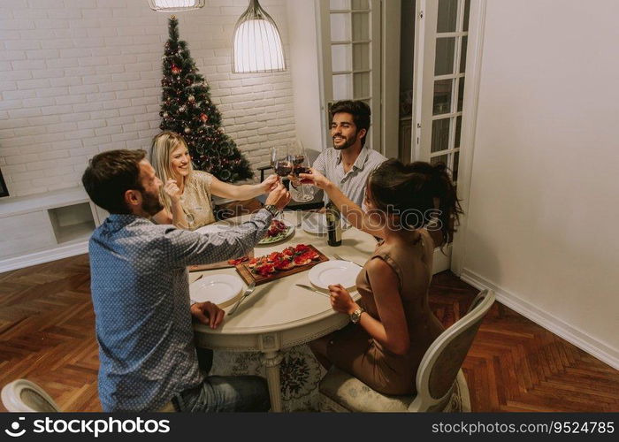 Young friends celebrating Christmas or New Year eve at home