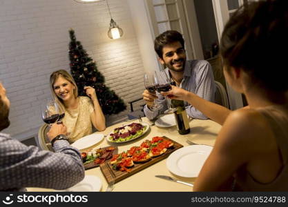 Young friends celebrating Christmas or New Year eve at home