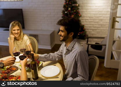 Young friends celebrating Christmas or New Year eve at home