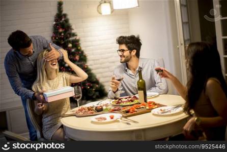 Young friends celebrating Christmas or New Year eve at home