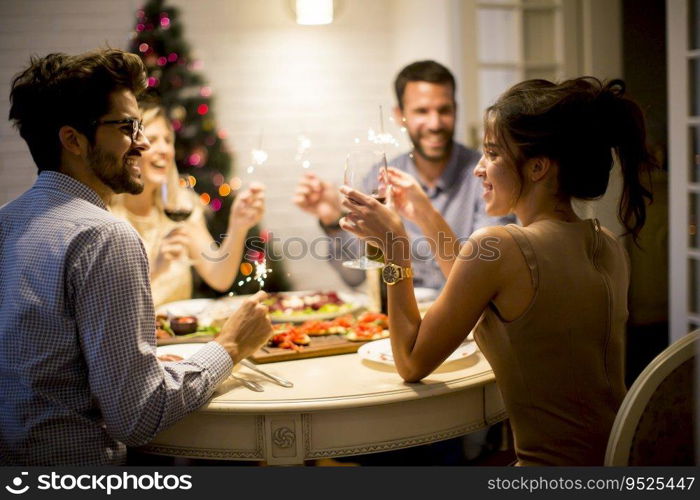 Young friends celebrating Christmas or New Year eve at home