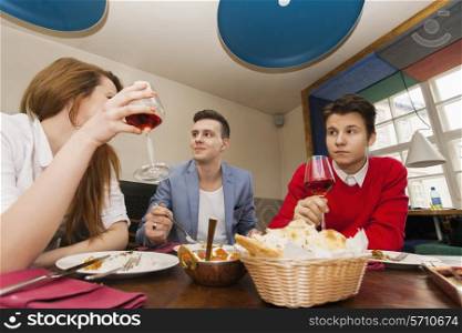 Young friends having meal at restaurant