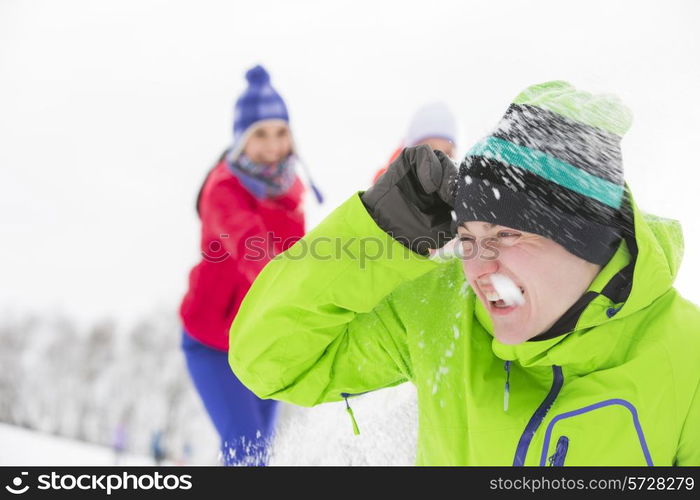 Young friends having snowball fight