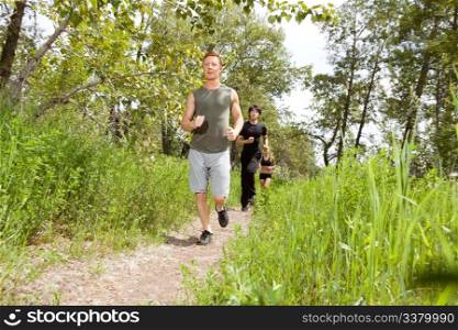 Young friends jogging in the forest on trail