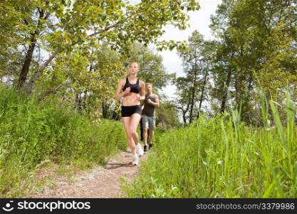 Young friends jogging together outdoors on a trail
