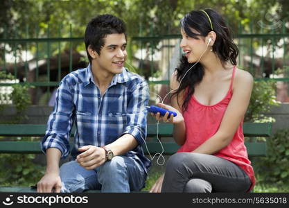 Young friends listening to music in lawn