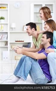 Young friends playing video games at home