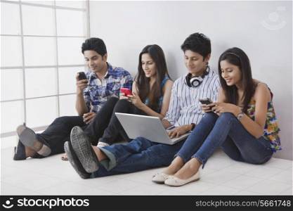 Young friends using technologies in college