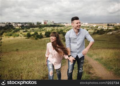 Young fun romantic couple is having fun around the city in summer sunny day. Enjoying spending time together in holiday. Valentine&rsquo;s Day. Young fun romantic couple is having fun around the city in summer sunny day. Enjoying spending time together in holiday. Valentine&rsquo;s Day.