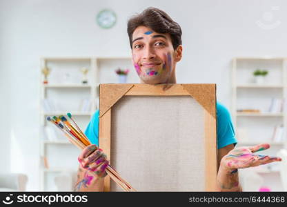 Young funny artist working on new painting in his studio