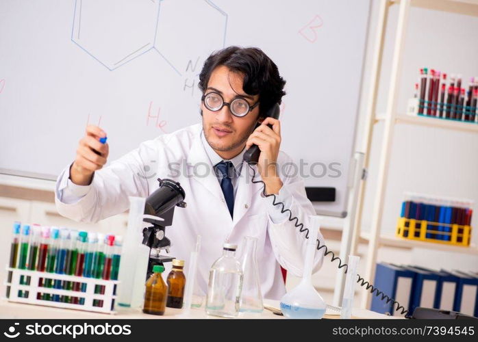 Young funny chemist in front of white board 