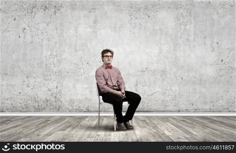 Young funny teenager guy sitting in chair. Funny man