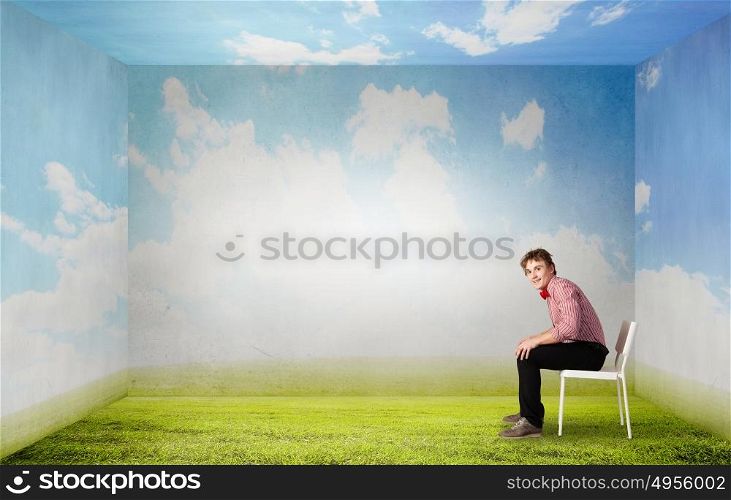 Young funny teenager guy sitting in chair. Funny man