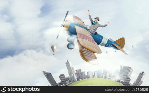 Young funny woman flying in air in retro airplane. Girl flying old plane