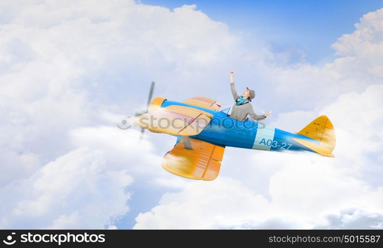 Young funny woman flying in air in retro airplane. Girl flying old plane