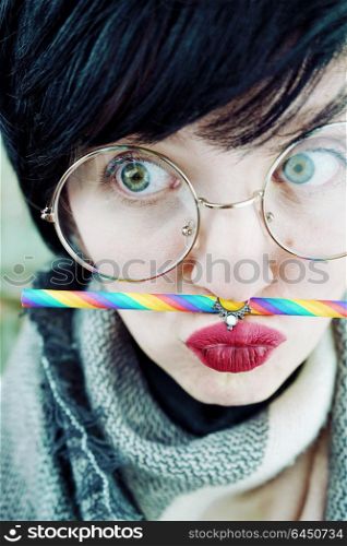 Young funny woman with a rainbow straw