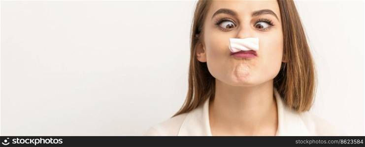 Young funny woman with sweet candy marshmallow-like mustache over white background. Depilation and epilation concept. Woman with candy marshmallow-like mustache