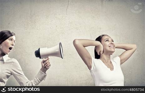 Young furious woman screaming agressively in megaphone. Agressive management