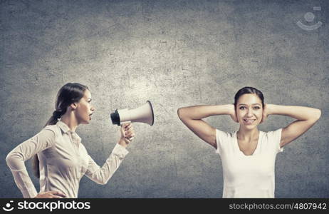 Young furious woman screaming agressively in megaphone. Agressive management