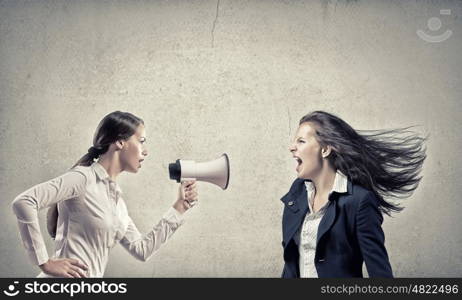 Young furious woman screaming agressively in megaphone. Agressive management