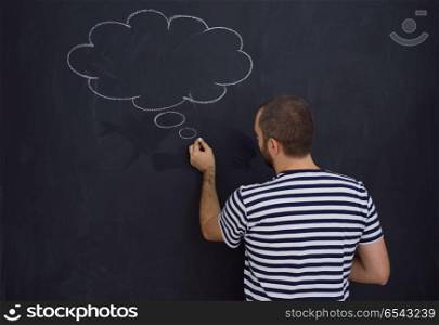 young future father thinking about names for his unborn baby to writing them on a black chalkboard. young future father thinking in front of black chalkboard