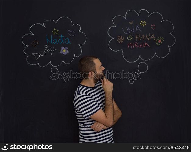 young future father thinking about names for his unborn baby to writing them on a black chalkboard. young future father thinking in front of black chalkboard