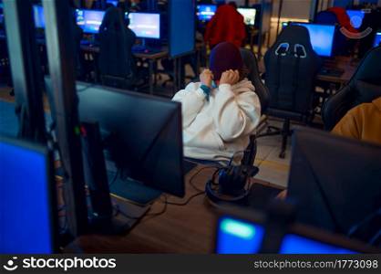 Young gamer staring at the monitor, game club. Virtual entertainment, e-sport tournament, cybersport lifestyle. Male person leisures in internet cafe. Young gamer staring at the monitor, game club