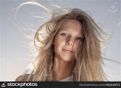 Young gender fluid person with long blond hair fly in the wind retro color