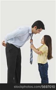 Young girl adjusting father&rsquo;s tie