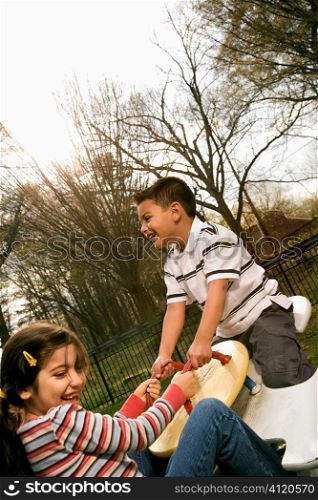 Young Girl and Boy Playing on Seesaw