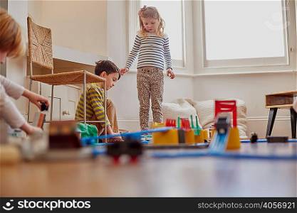 Young girl and boy playing with toy train set