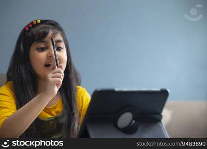 Young girl asking a question with a pencil in her hand during virtual class