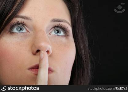 Young girl asking for silence beautiful woman with finger on her lips - copyspace