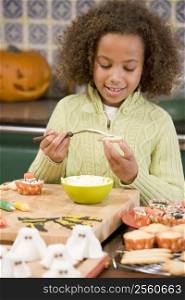 Young girl at Halloween making treats and smiling