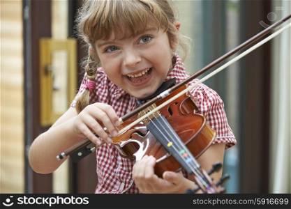 Young Girl At School Learning To Play Violin