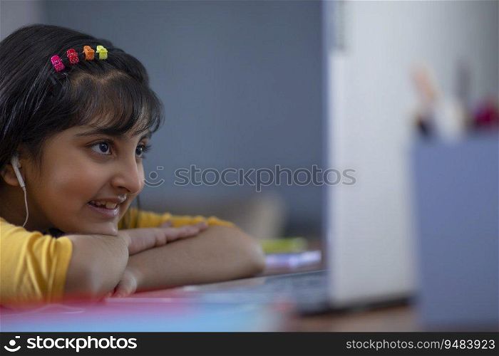 Young girl attending online class on her laptop 