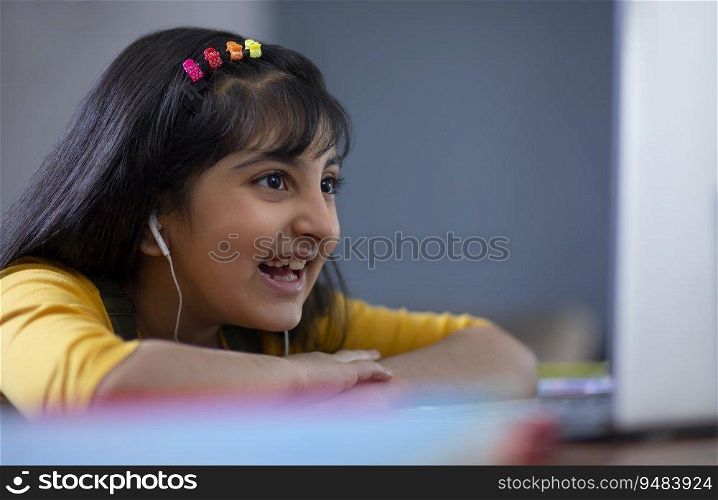 Young girl attending online class on her laptop 