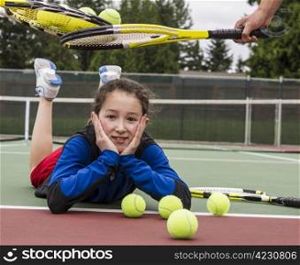 Young girl being given acceptance into tennis group with rackets over her head